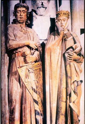 Le comte Ekkehard et la comtesse Uta - sculptés vers 1250 - Cathédrale Saint-Pierre et Saint-Paul de Naumbourg.
Les vêtements sont à gros plis, masquant la silhouette.
Encolure peu dégagée et ronde, Cape et manteau sont retenus par un fermail.
On voit nettement les banquelets qui ornent la ceinture du comte.